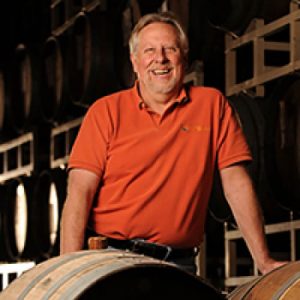 Michael Blaylock leaning on wine barrels at Quady Winery in Madera, California.