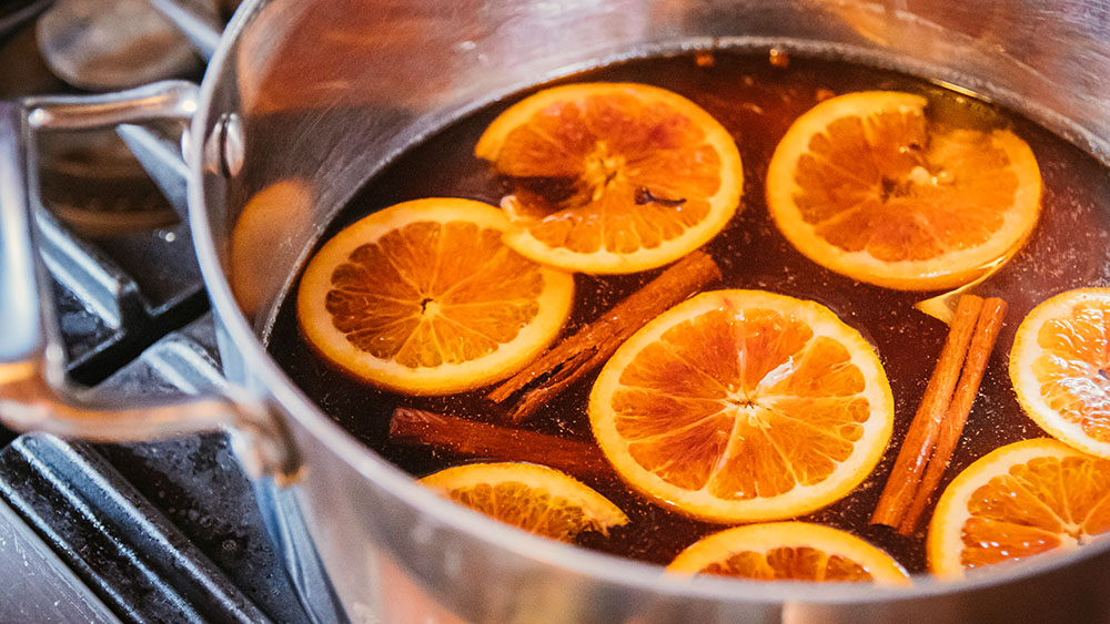 Orange slices and cinnamon sticks simmering for Mulled Wine Cocktail