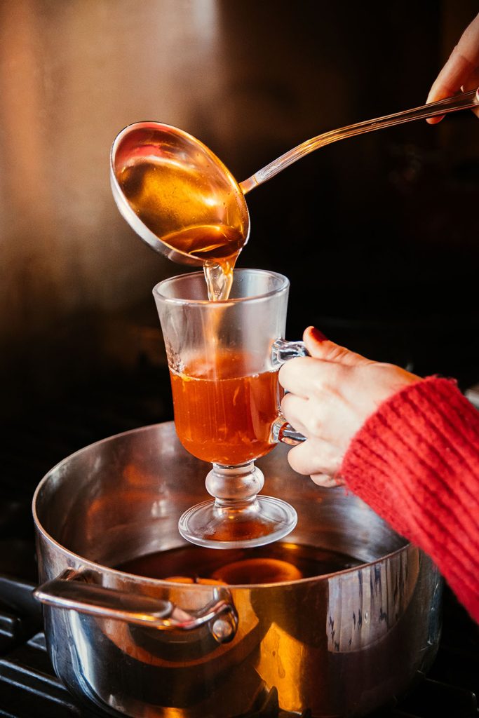 Pouring Mulled Wine Cocktail into hot toddy glass