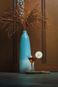 Northern Comfort Apple Brandy Cocktail with a vase and fall foliage