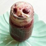 Elysium Sundae in a mason jar glass topped with whipped cream and cherries.