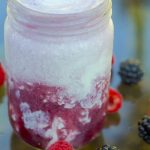 Red Electra Moscato wine ice cream float in a mason jar glass surrounded by raspberries and blackberries.