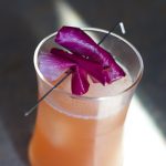 Swinging angel cocktail topped with fresh flower petals.
