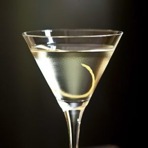 Martini cocktail in a martini glass with a lemon peel garnish.
