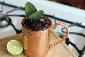 Vya Western Sage Mule cocktail in a mule glass garnished with blackberries.