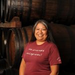 Cynthia Leon in front of wine barrels at Quady Winery in Madera, California.