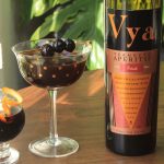 Bottle of Vya Sweet Vermouth next to two cocktails.