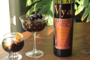 Bottle of Vya Sweet Vermouth next to two cocktails.