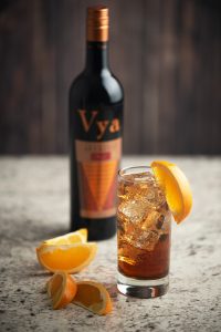 Vya Sweet Vermouth and soda with orange wedges and a bottle of Vya Sweet Vermouth