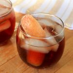 2 Perfect Port Punch cocktails in glasses filled with ice and grapefruit garnishes.