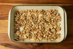 Baking dish filled with raw walnuts.