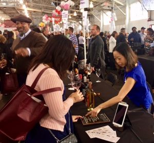 Quady employee at the san francisco chronicle wine competition and tasting pouring Quady sweet wine for attendees to taste.
