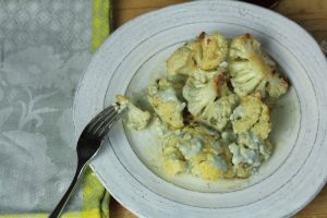 Roasted cauliflower and blue cheese dressing on a plate.