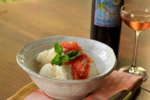 Bowl of ice cream, grapefruit puree and mint leaf next to a bottle and glass of Deviation dessert wine.
