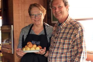 Andrew and Laurel Quady in their kitchen holding a dish of Abelskevers.
