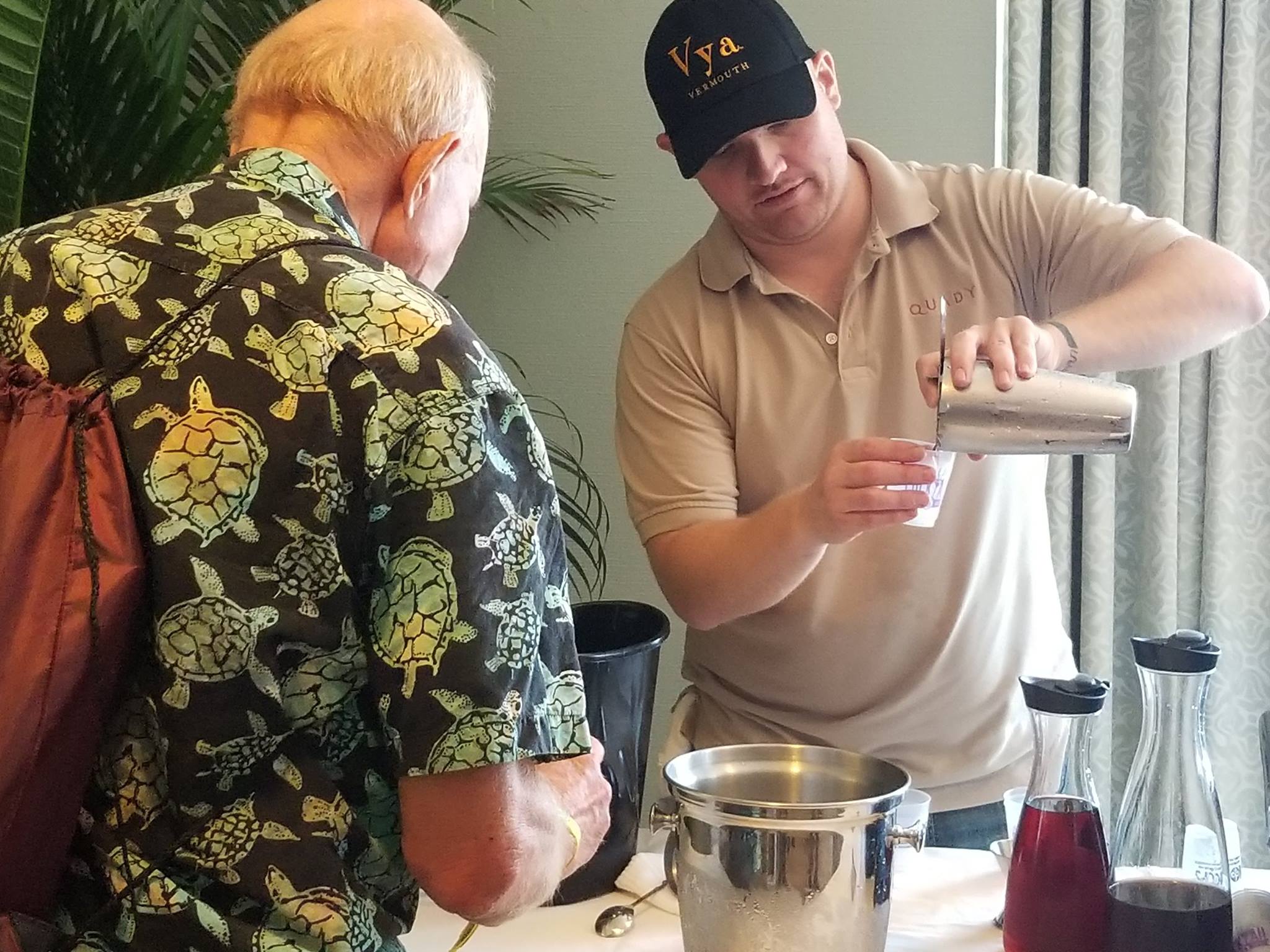 A Quady winery employee pouring a cocktail for tasting to an attendee at the Vya Vermouth tasting and seminar at tales of the cocktail.