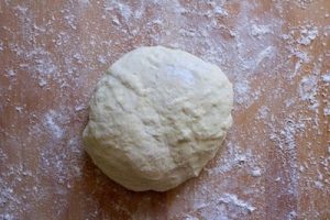 Ball of flat bread dough with flour.