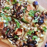 Baked fig and arugula flat bread cut into pieces.