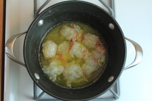 Butter poached lobster in a pot on the stove.