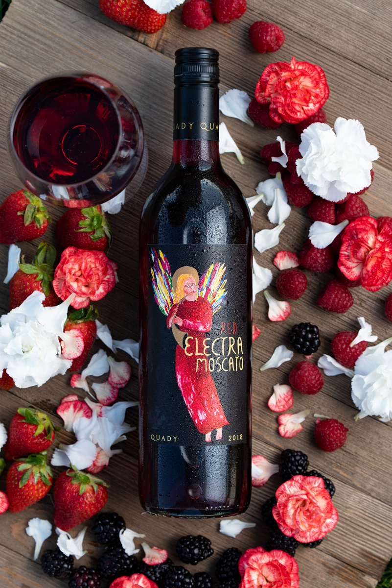 New Red Electra Moscato wine packaging, surrounded by flowers, raspberries and strawberries