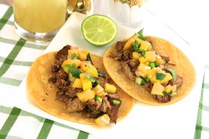Quady Winery's Killer Carnitas Tacos with Mango Salsa on a table next to an Essensia Orange Muscat Dessert Wine margarita cocktail