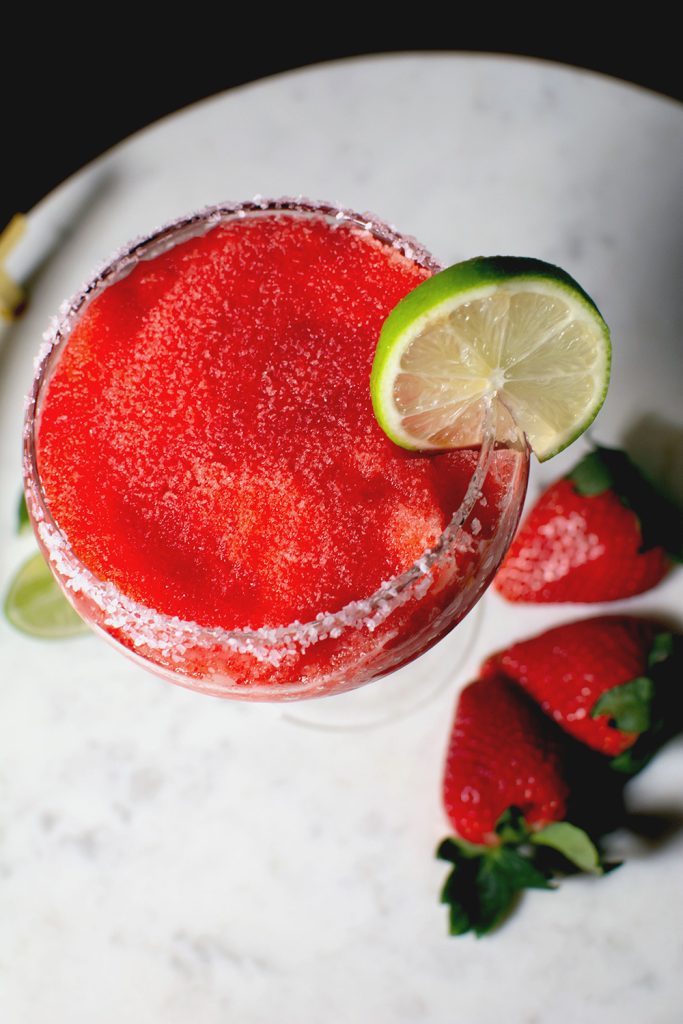 Red Electra Frozen Cherry-Berry Margarita with lime garnish and strawberries