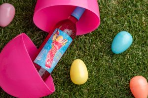 Bottle of Electra Moscato Rosé Wine in a large Easter egg on grass next to smaller Easter eggs.