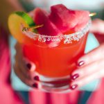 Two hands holding Quady Watermelon Margarita with Red Electra Moscato, Watermelon and tequila in a rocks glass