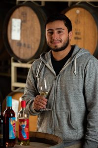 Hector Martinez, General Winery Worker at Quady Winery, holding a glass of Electra Moscato.