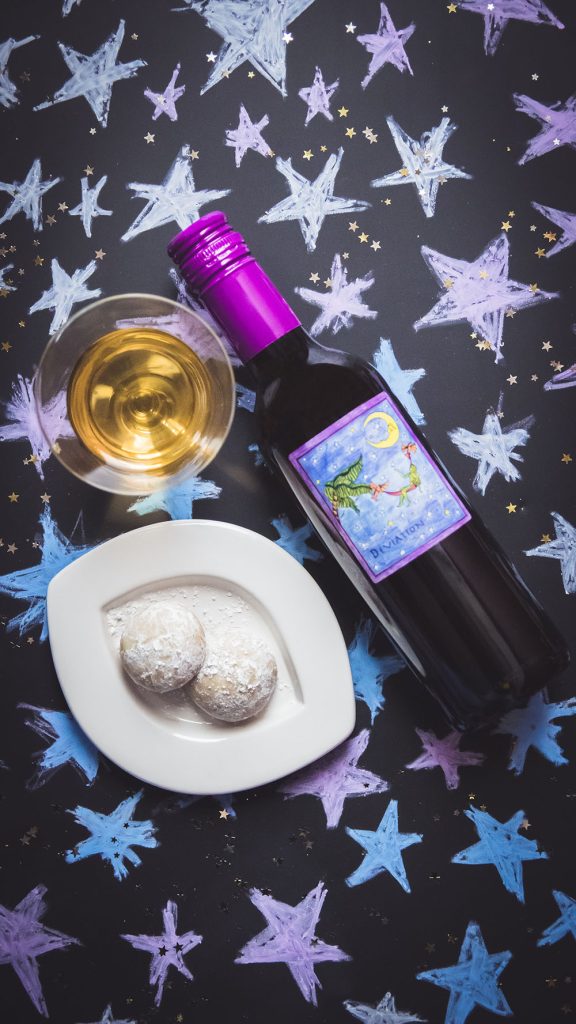 Bottle and glass of Deviation dessert wine with a plate of pfeffernusse cookies