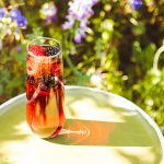 Red Electra Moscato Mimosa with berries, photographed with wildflowers in the backgroud