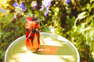 Red Electra Moscato Mimosa with berries, photographed with wildflowers in the backgroud