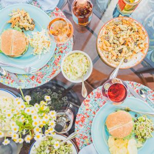 Plates with burgers and side dishes of coleslaw and pasta salad