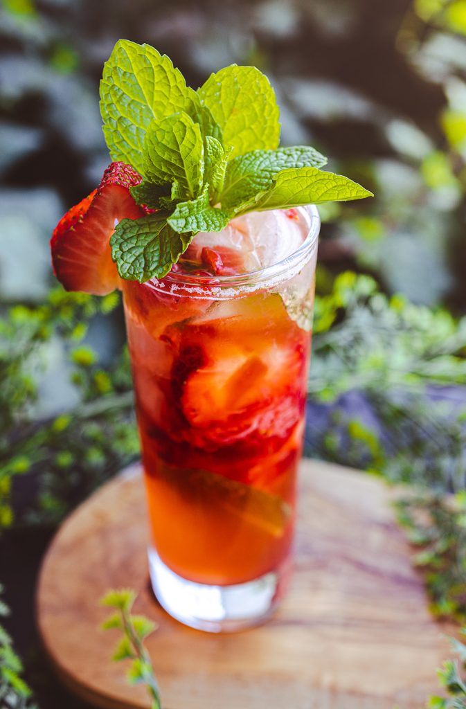 Strawberry Rosé Mojito Cocktail surrounded by greenery