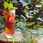 Strawberry Rosé Mojito surrounded by greenery and ivy in the background