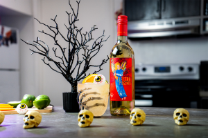 Halloween Party Punch with a bottle of Electra Moscato, limes, mini skulls and a black glitter tree.